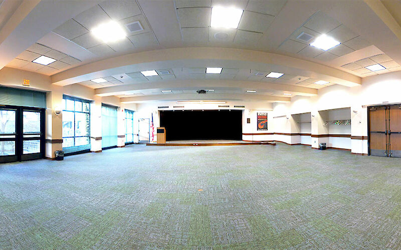 A wide view of nearly the full physical space of the room with the platform stage as the focus.