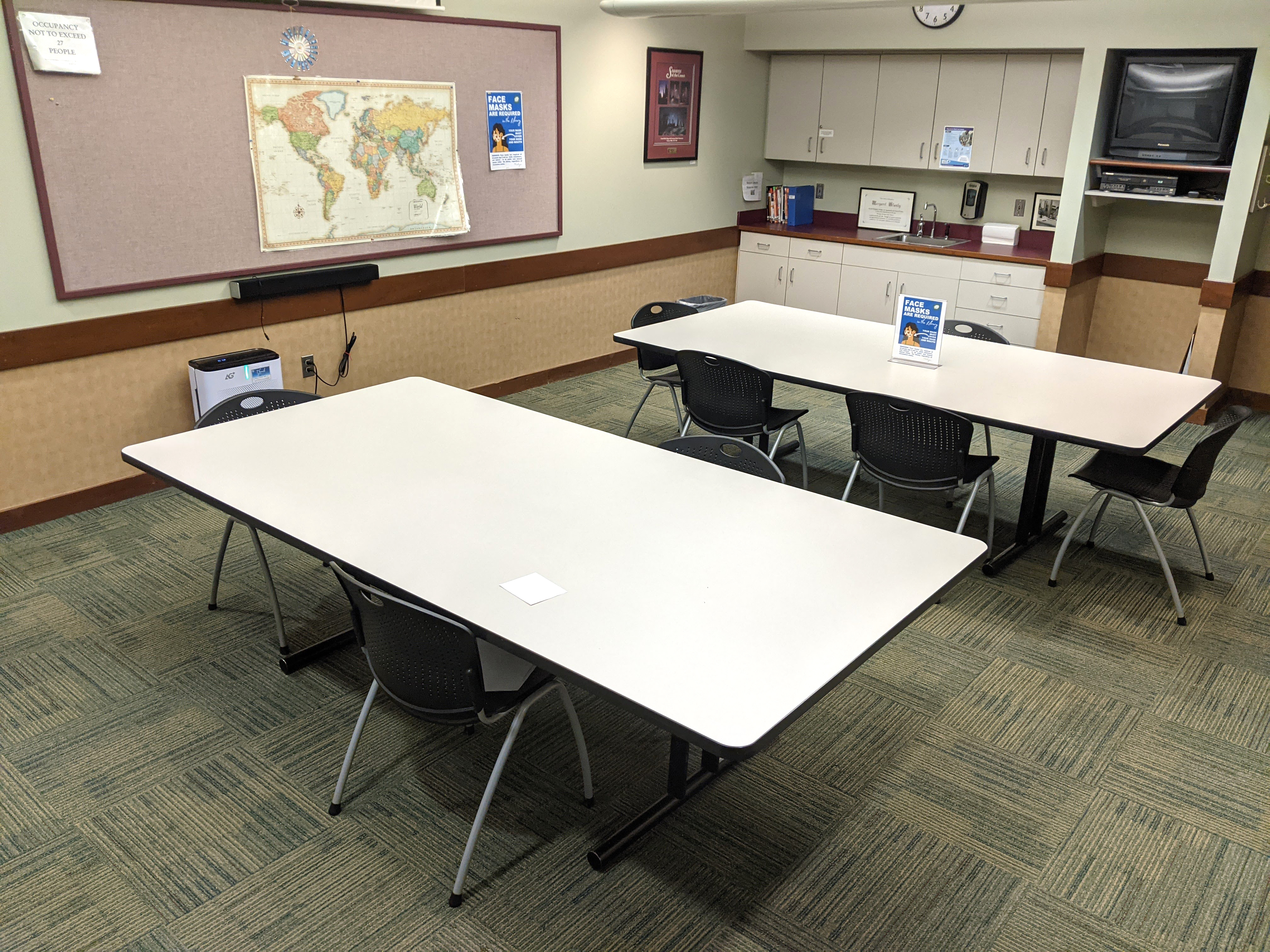 Tables and chairs viewed from the far end of the room.