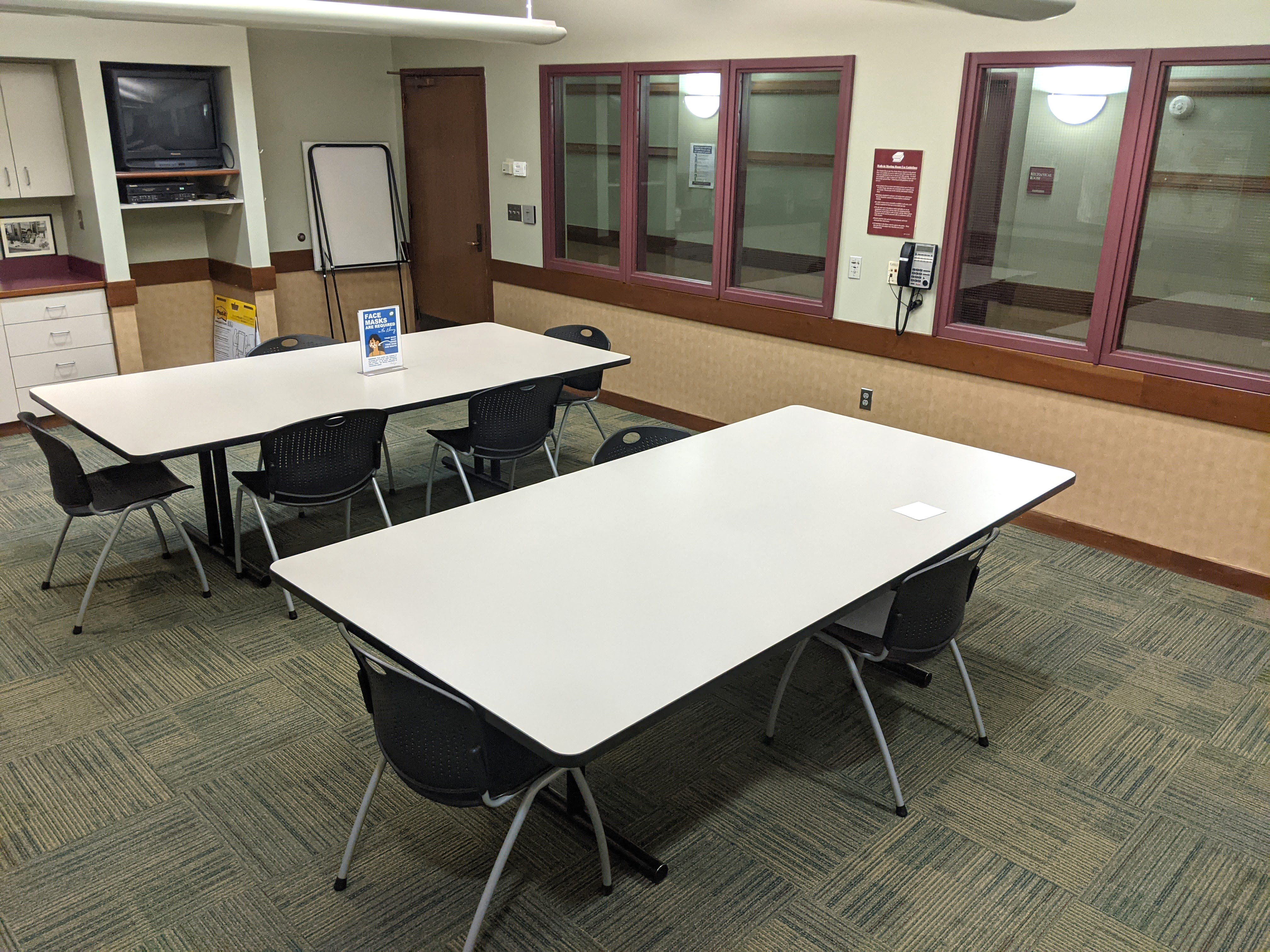 Tables and chairs from the far corner of the room looking towards the entry door.