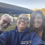 Thumbnail: 3 people smiling at the camera.  Man on left in black shirt with glasses.  Woman in middle with blue sweatshirt and glasses.  Woman on right in black shirt